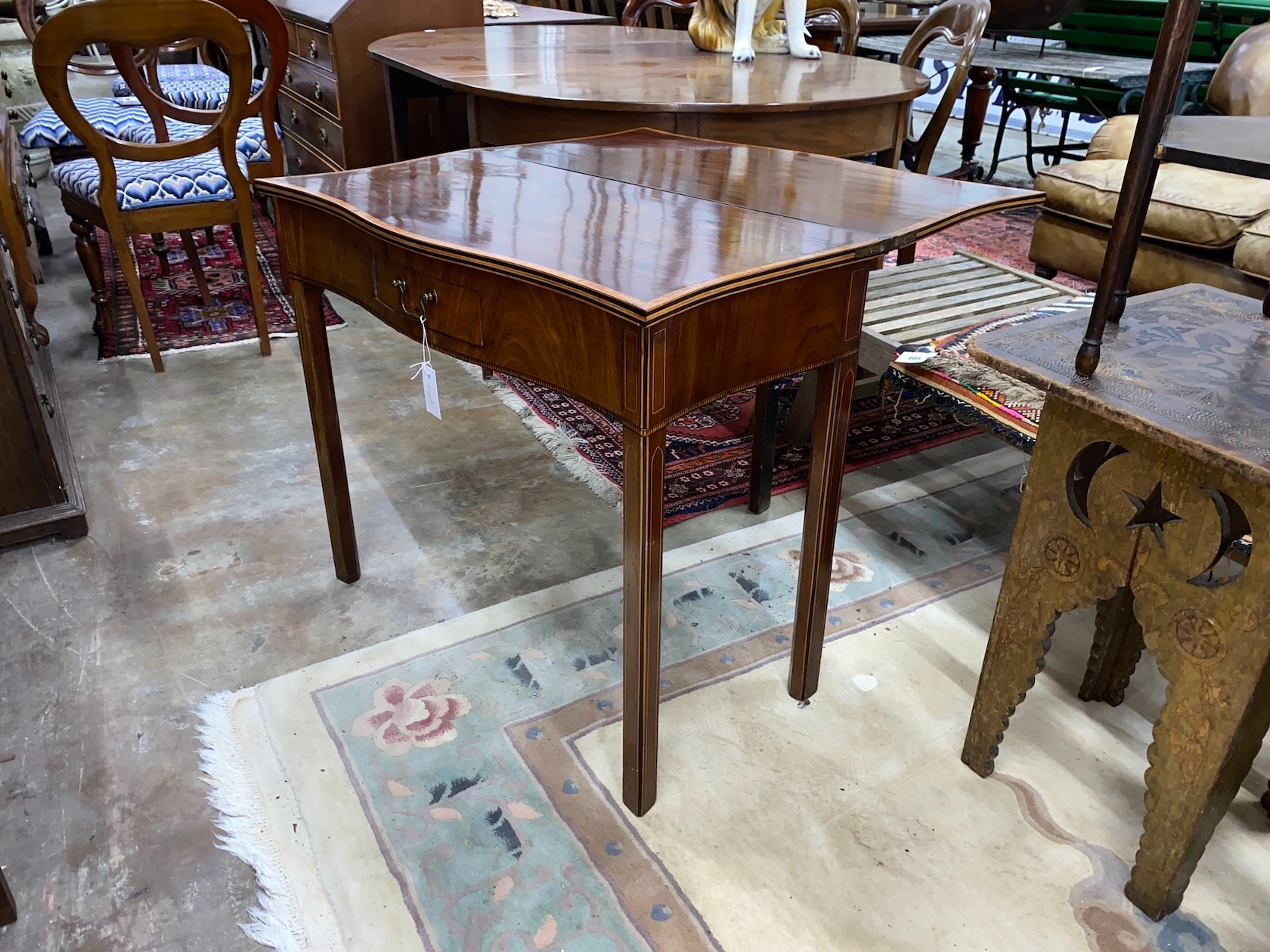 A George III satinwood banded serpentine mahogany folding tea table, width 84cm, depth 42cm, height 74cm
